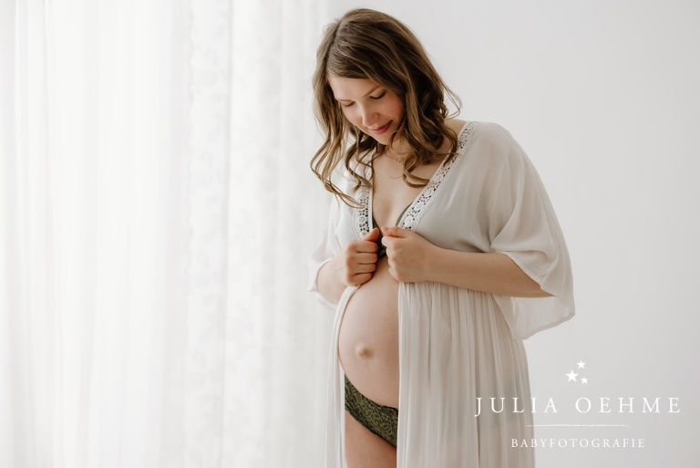 schwangere mit weißem Mantel bei babybauchshooting in leipzig