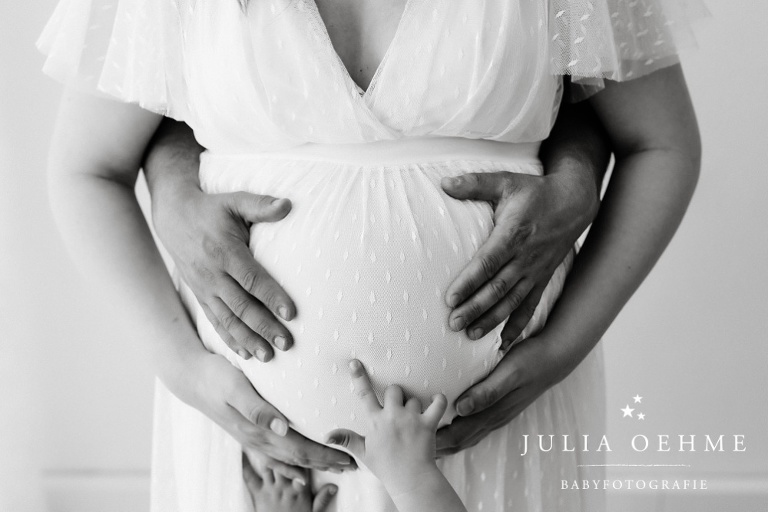 süsses babybauchfoto mit großer schwester und allen händen am babybauch